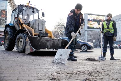 Екатеринбург. Дворники с помощью лопат и трактора убирают снег с улицы.