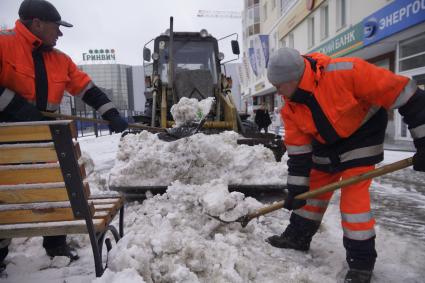 Екатеринбург. Дворники с помощью лопат и трактора убирают снег с улицы.