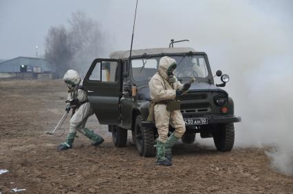 Московская область. Военнослужащие ВДВ в общевойсковом защитном комплекте и с прибором измерителем мощности дозы ИМД-2НМ (слева) во время занятий по химподготовке.