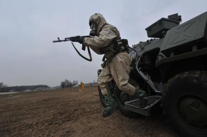 Московская область. Военнослужащие ВДВ в общевойсковом защитном комплекте у бронетранспортера во время занятий по химподготовке.