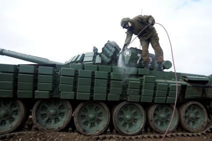 Челябинская область. Чебаркульский военный полигон. Военнослужащий поливает растворителем танк Т-72 в ходе испытания краски с антиобледенительным, маскировочным и радиодезактивирующим свойствами.