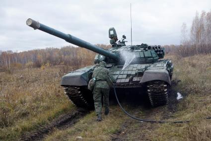 Челябинская область. Чебаркульский военный полигон. Военнослужащий проводит противорадиационную обработку танка Т-72, в ходе испытания краски с антиобледенительным, маскировочным и радиодезактивирующим свойствами.