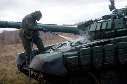 Челябинская область. Чебаркульский военный полигон. Военнослужащий проводит противорадиационную обработку танка Т-72, в ходе испытания краски с антиобледенительным, маскировочным и радиодезактивирующим свойствами.