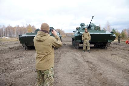 Челябинская область. Чебаркульский военный полигон. Военнослужащий смотрит через прибор ночного видения на покрашеный краской БМП-2, в ходе испытания краски с антиобледенительным, маскировочным и радиодезактивирующим свойствами.