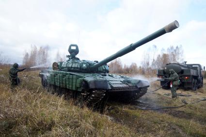 Челябинская область. Чебаркульский военный полигон. Военнослужащие проводит противорадиационную обработку танка Т-72, в ходе испытания краски с антиобледенительным, маскировочным и радиодезактивирующим свойствами.