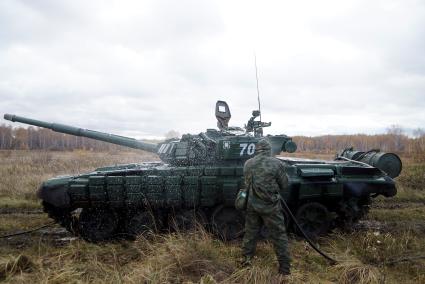 Челябинская область. Чебаркульский военный полигон. Военнослужащий проводит противорадиационную обработку танка Т-72, в ходе испытания краски с антиобледенительным, маскировочным и радиодезактивирующим свойствами.