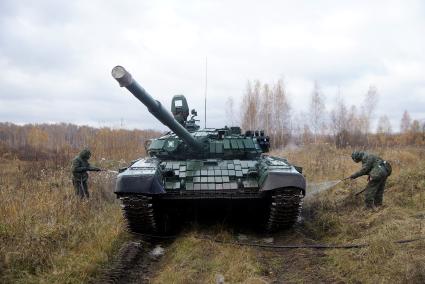 Челябинская область. Чебаркульский военный полигон. Военнослужащие проводит противорадиационную обработку танка Т-72, в ходе испытания краски с антиобледенительным, маскировочным и радиодезактивирующим свойствами.