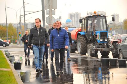 Москва.  Заместитель мэра Москвы по вопросам жилищно-коммунального хозяйства и благоустройства Петр Бирюков (второй слева) принял участие в высадке деревьев в рамках программы `Моя улица` вдоль Каширского шоссе.