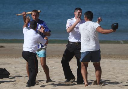 Краснодар. Полицейские разнимают дерущихся мужчин на пляже.