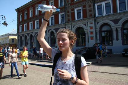 Нижний Новгород. Девушка поливает себя водой из пластиковой бутылки.