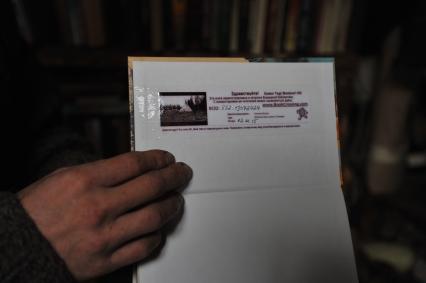 Владимирская область.  Отшельник  Юрий, живущий в землянке на 106-м километре  Ярославского шоссе, демонстрирует журналисту книгу  из своей библиотеки.