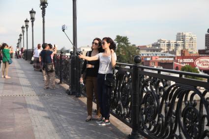 Москва. Туристы делают селфи на Патриаршем мосту.