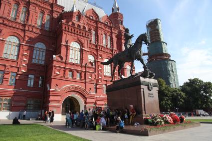 Москва. Туристы прячутся от солнца в тени памятника маршалу Георгию Жукову.