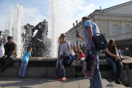 Москва. Девушка фотографируется на фоне скульптурной группы `Времена Года` фонтана `Гейзер`.