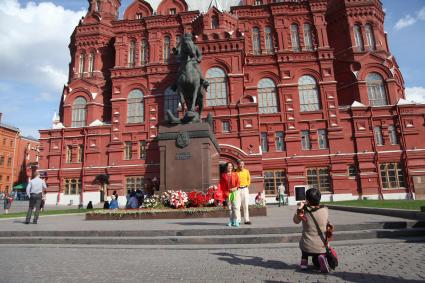 Москва. Туристы фотографируются на фоне памятника маршалу Георгию Жукову.