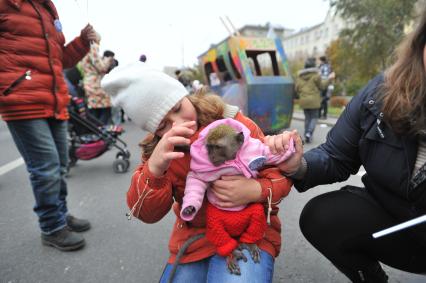 Москва. Девочка держит на руках обезьянку во время праздника московского троллейбуса на Фрунзенской набережной.