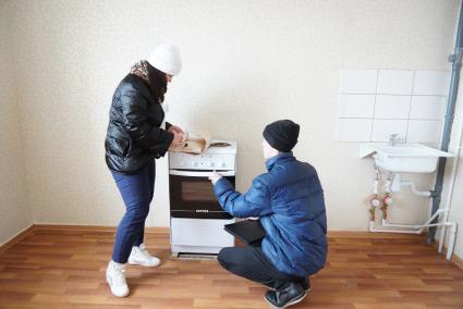 Свердловская область, г. Серов. Супруги осматривают кухню своей квартиры в новом доме, полученной по программе `Доступное жилье` для молодых семей.