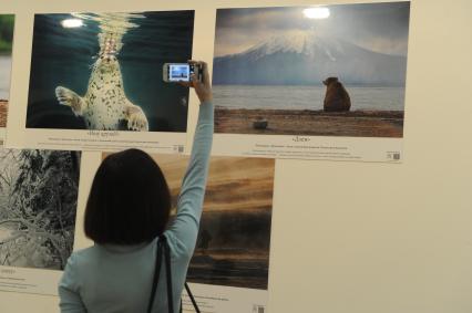 Москва.   Посетительница на фотовыставке, проходящей в рамках II Фестиваля Русского географического общества в Центральном доме художника.