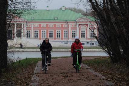 Москва.  Усадьба Кусково. Женщины катаются на велосипеде в парке.