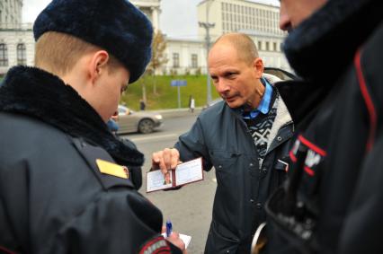 Москва. Сотрудники полиции проверяют документы у активиста  Валентина Карелина, организовавшего одиночный пикет  рядом с местом  установки памятника святому равноапостольному князю Владимиру на Боровицкой площади.