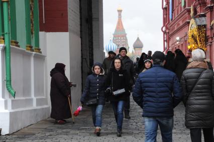 Москва.  Женщина просит милостыню у прохожих  около  Воскресенских  ворот.