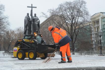 Москва.  Дворник чистит снег у памятника Кириллу и Мефодию на Славянской площади.