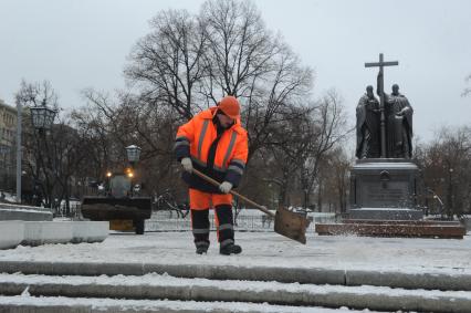 Москва.  Дворник чистит снег у памятника Кириллу и Мефодию на Славянской площади.