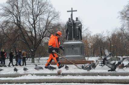 Москва.  Дворник чистит снег у памятника Кириллу и Мефодию на Славянской площади.