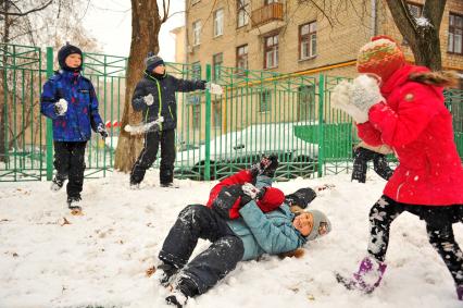 Москва.  Мальчики дерутся на снегу.