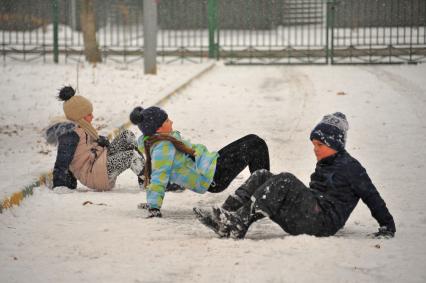 Москва.  Дети сидят на снегу.