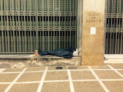 Греция, Афины. Бездомный спит возле здания Банка Греции.