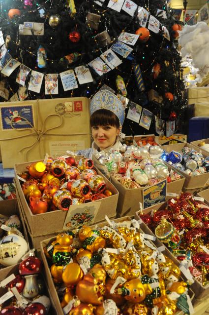 Москва. Продавец в костюме Снегурочки на новогодней ярмарке в ГУМе.
