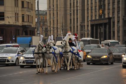 Москва.  Главный Дед Мороз страны из Великого Устюга и Снегурочка едут к Центральному детскому магазину  по Тверской улице.