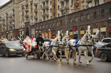 Москва.   Главный Дед Мороз страны из Великого Устюга и Снегурочка едут к Центральному детскому магазину  по Тверской улице.