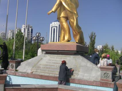 Туркмения. Ашхабад. Женщина моет памятник первому президенту Туркмении Сапармурату Ниязову.