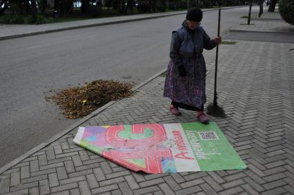 Абхазия. Сухум. Дворник подметает листву на улице.