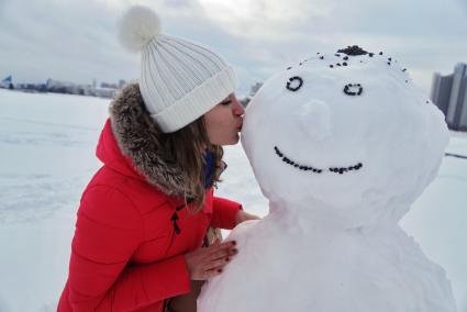 Екатеринбург. Девушка целует снеговика.