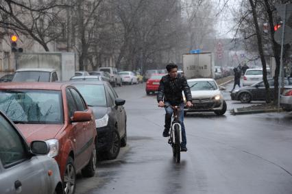 Москва. Велосипедист едет по дороге.