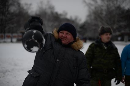 Москва. Мужчина подкидывает гирю в парке Кузьминки.