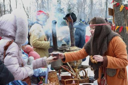 Самара. Фестиваль `Славянская зима` в культурном центре `Светлица`. Девушка угощает горячим чаем из настоящего русского самовара.