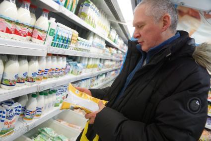 Екатеринбург. Покупатель выбирает молоко в супермаркете `Перекресток`.