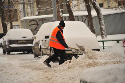 Последствия метели в Москве. Дворник убирает снег.