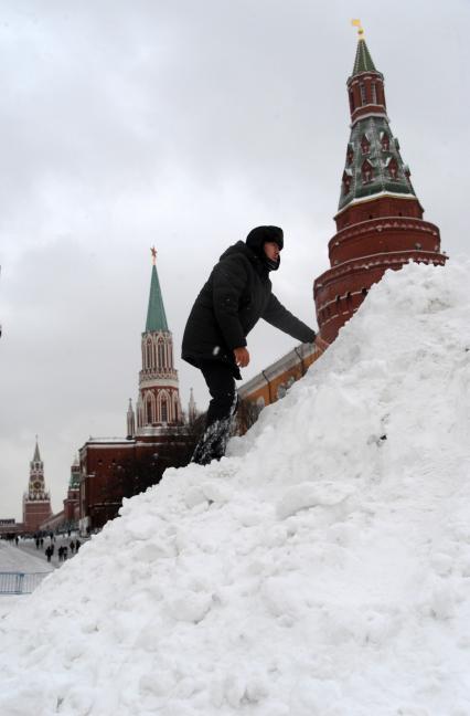 Москва. Мужчина стоит на сугробе на Красной площади.