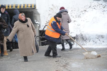 Москва. Дворник убирает снег у входа на станцию метро `Выхино`.