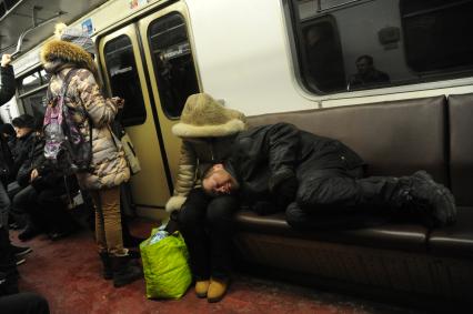 Москва. Бомж спит в вагоне метро.