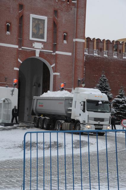 Москва. Самосвал со снегом выезжает из ворот Спасской башни Кремля.