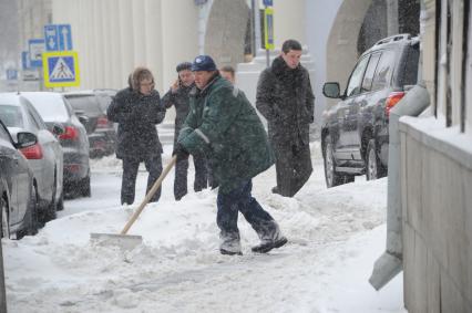 Москва. Дворник убирает снег на улице.