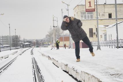 Тула. Мужчина ждет пригородный поезд.