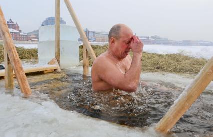 Крещенские купания в Санкт-Петербурге. Мужчина окунается в прорубь в Неве.