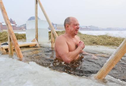 Крещенские купания в Санкт-Петербурге. Мужчина окунается в прорубь в Неве.